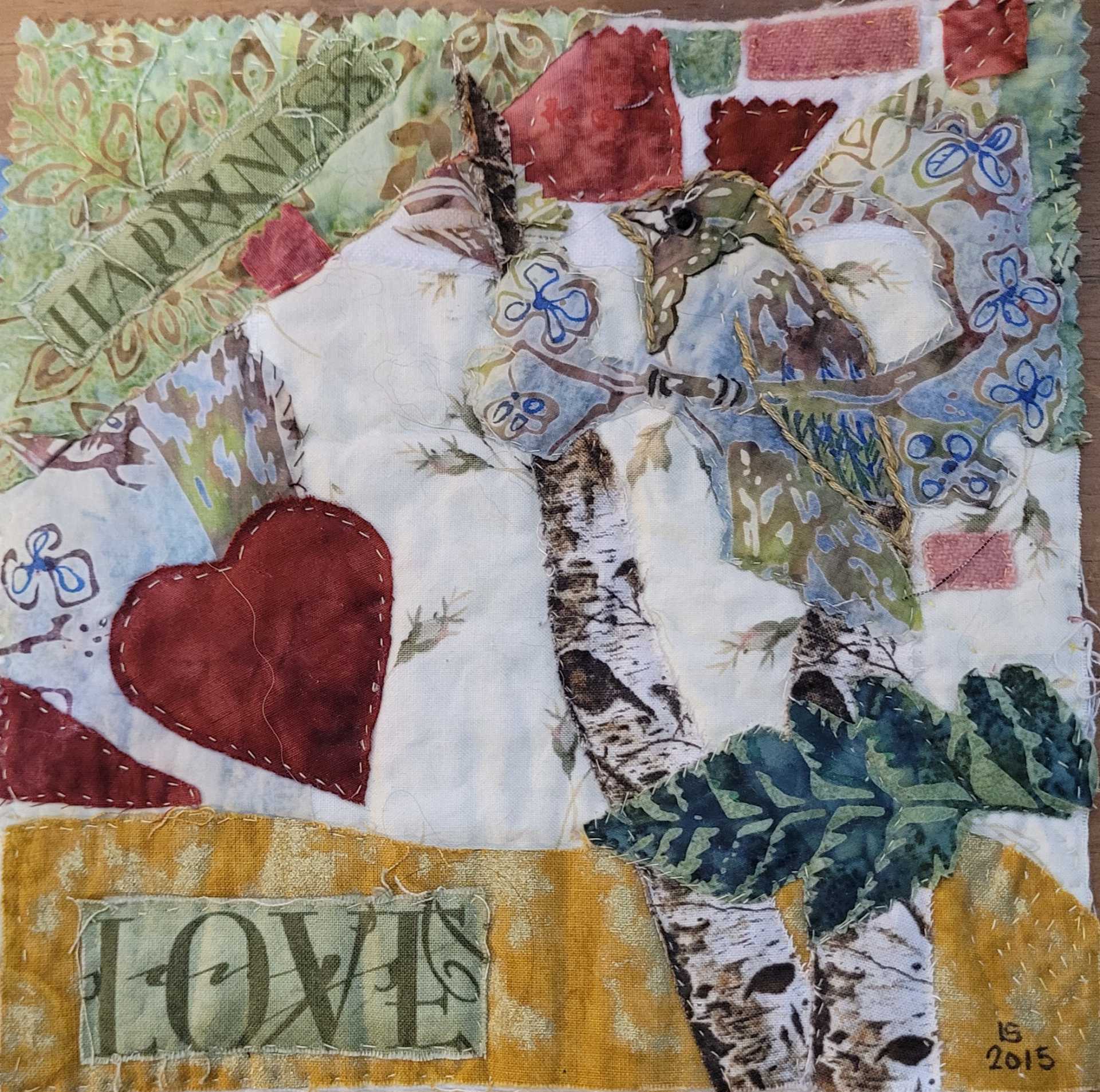 A homemade patchwork quilt with "Love" and "Happiness" embedded in the pattern.