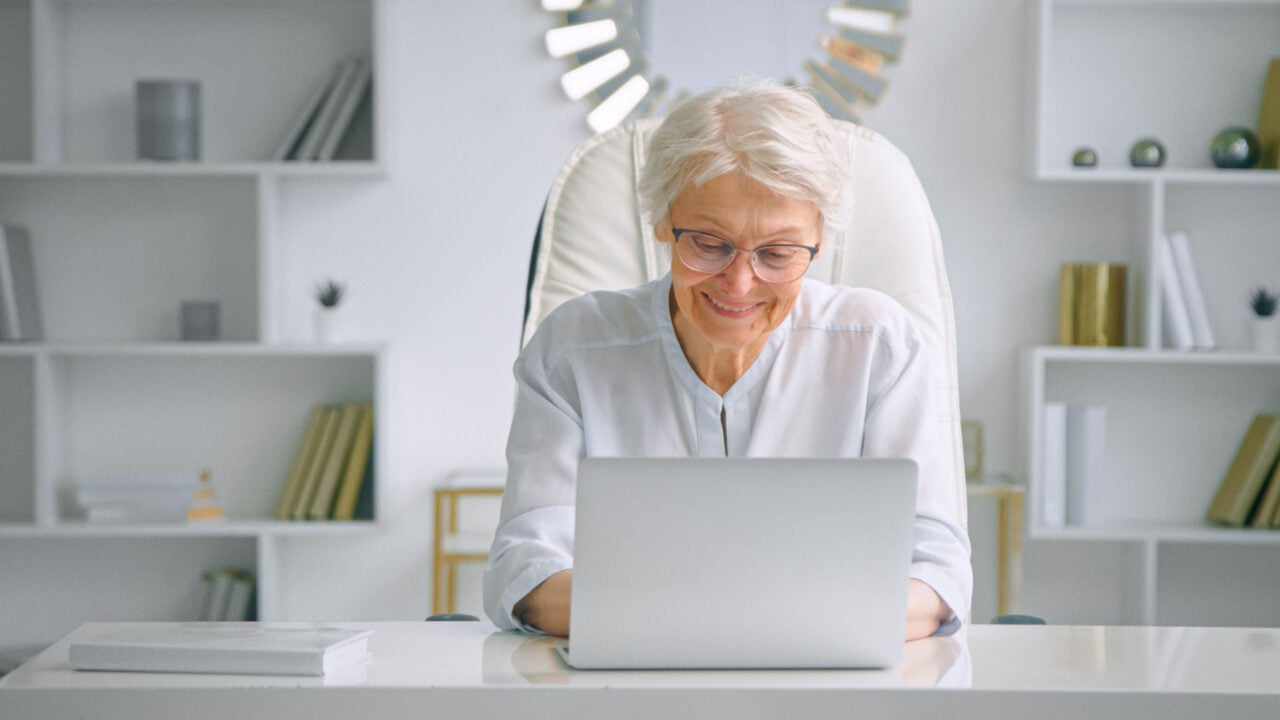 Senior Woman At Desk With Laptop